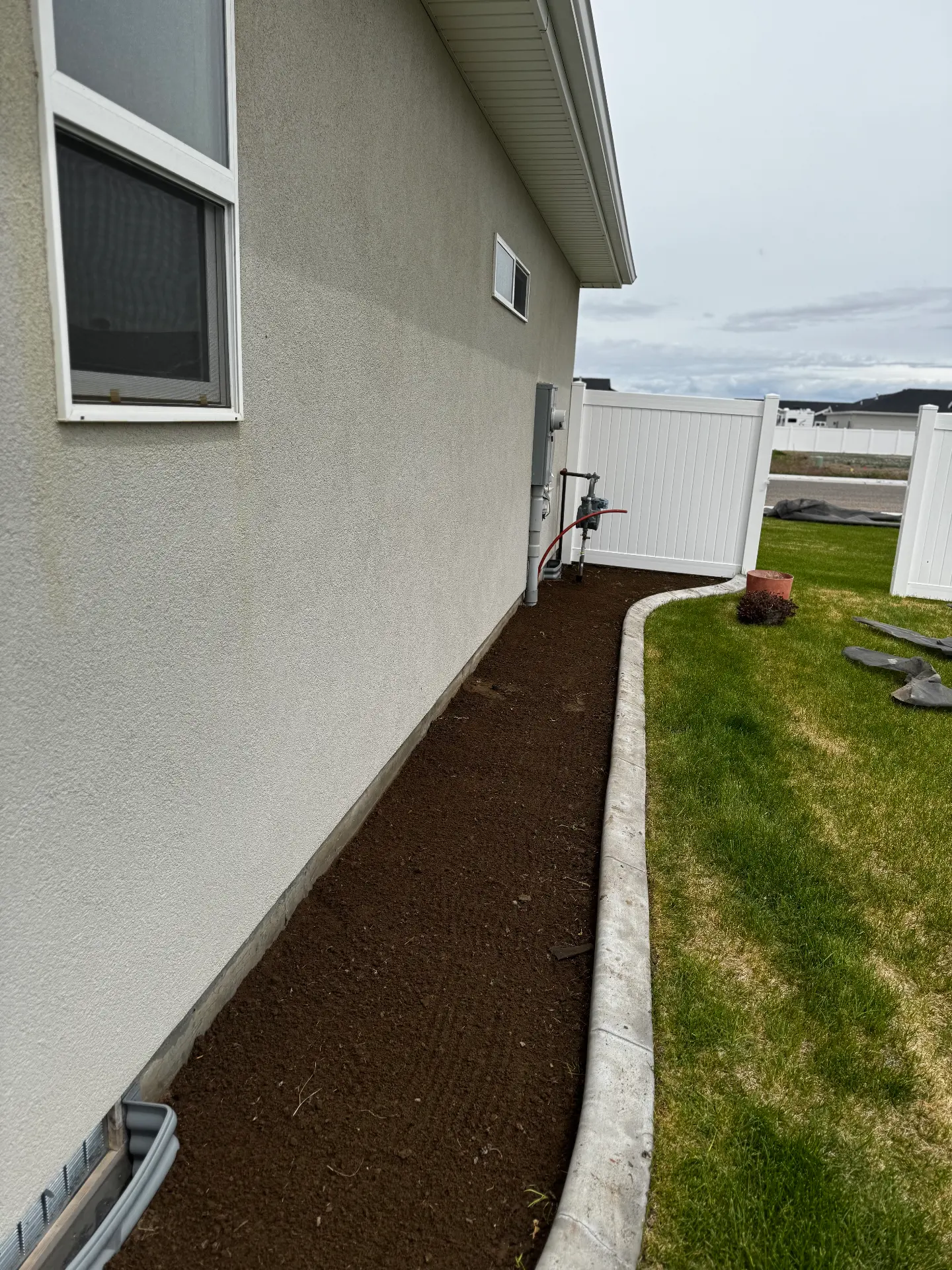 Concrete landscape curbing and fresh bark along a home — R & R Construction, Burley Idaho