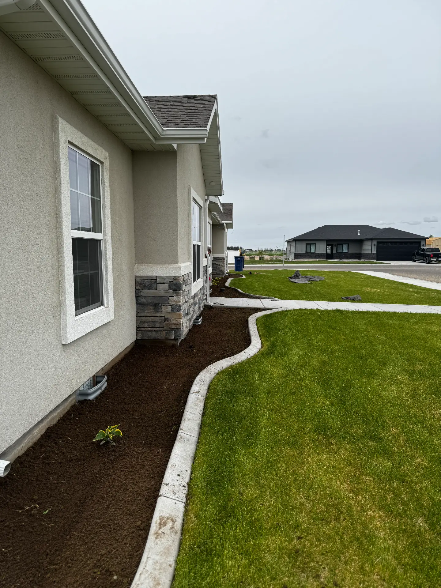 Concrete curbing framing a fresh landscape bed and lawn edge — R & R Construction, Burley Idaho