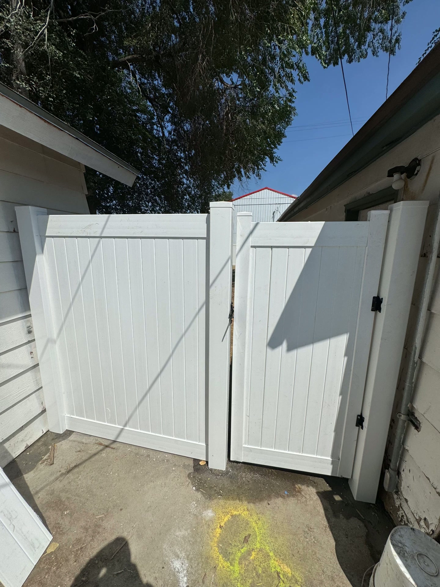 White vinyl double gate installed between two buildings — R & R Construction, Burley Idaho