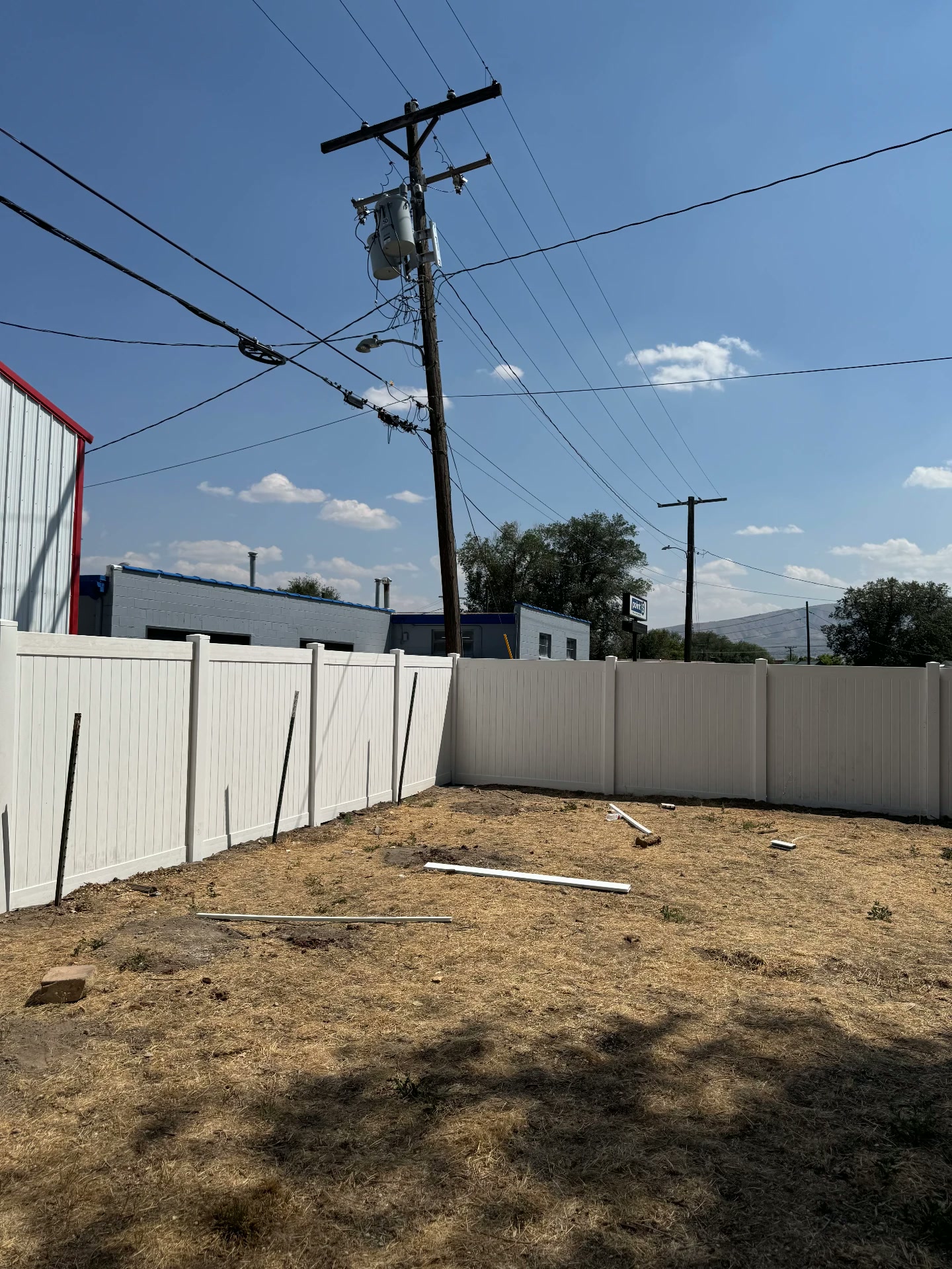 White vinyl privacy fence enclosing a full backyard corner — R & R Construction, Burley Idaho