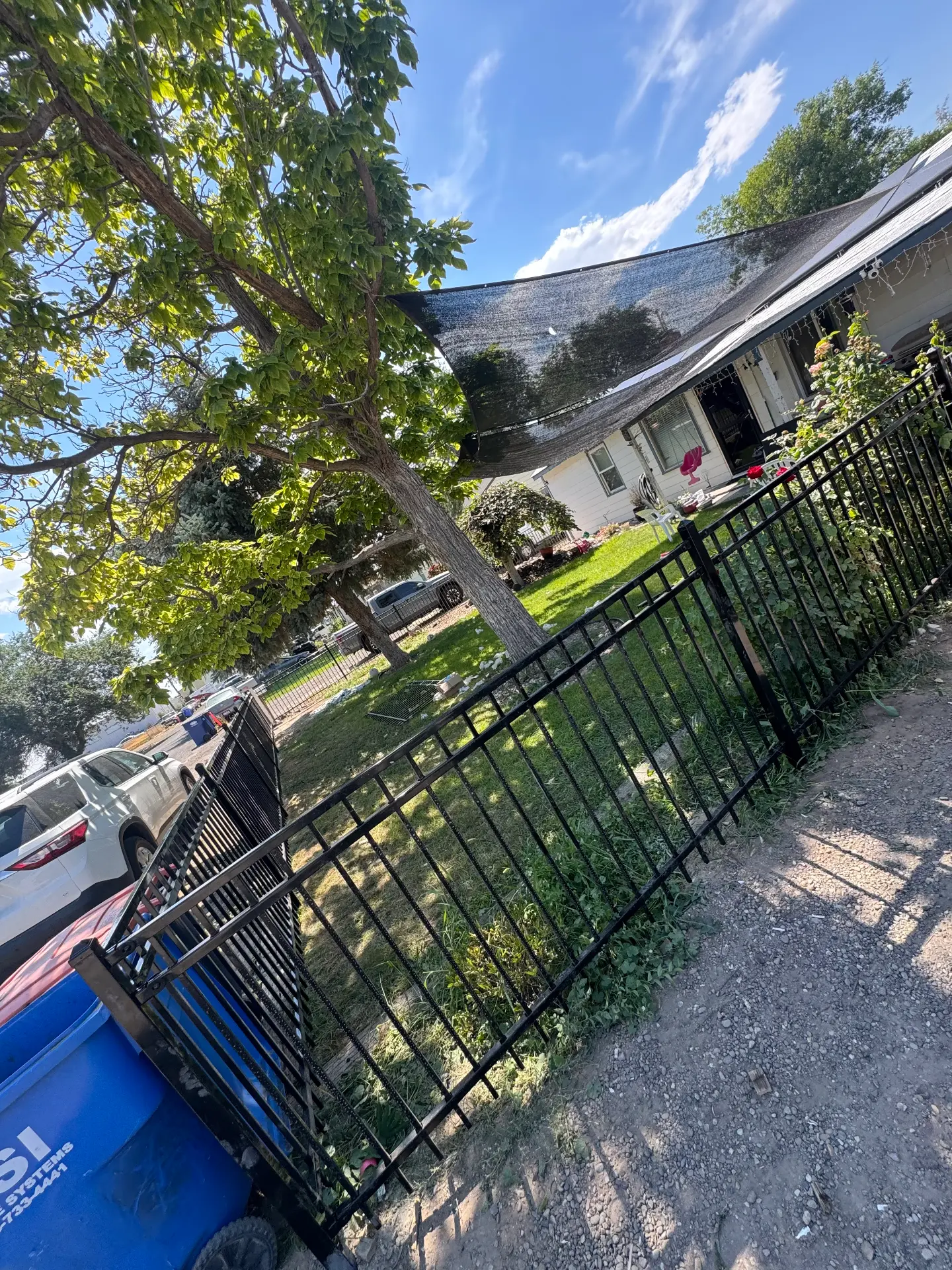 Black ornamental iron fence framing a shaded backyard — R & R Construction, Burley Idaho